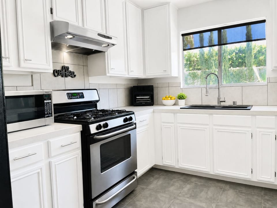 Bright kitchen with gas range, microwave, air fryer, and ample counter space