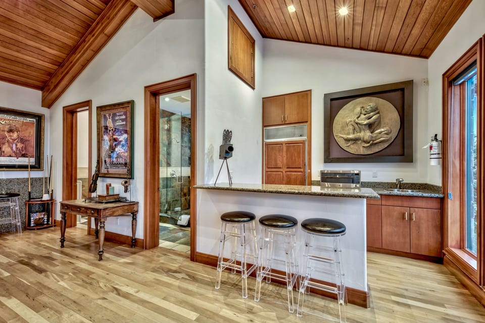 Wet bar in the game room with refrigerator and sink. Also his and hers bathrooms. Mens bathroom has a Urinal.