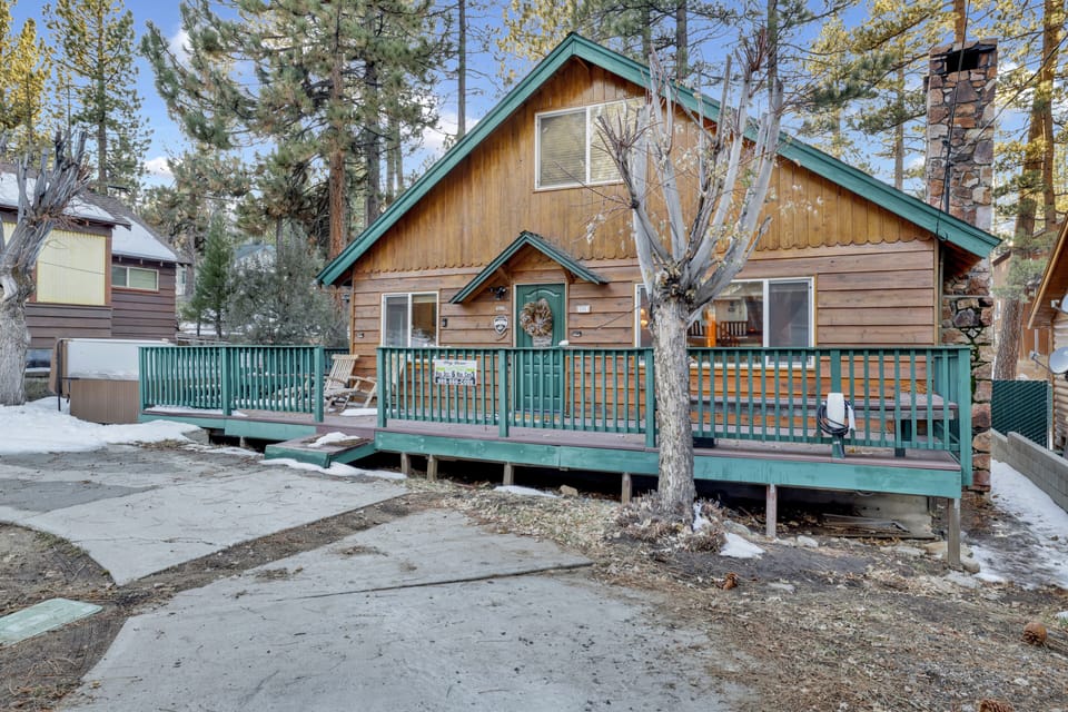 Welcoming cabin entry surrounded by towering pine trees, offering fresh mountain air and a peaceful forest setting—the perfect first impression for your Big Bear Lake getaway.