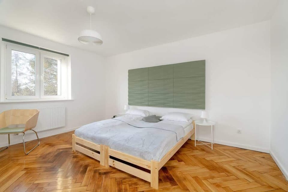 Another view of the bedroom, featuring a simple and elegant arrangement with soft bedding.
