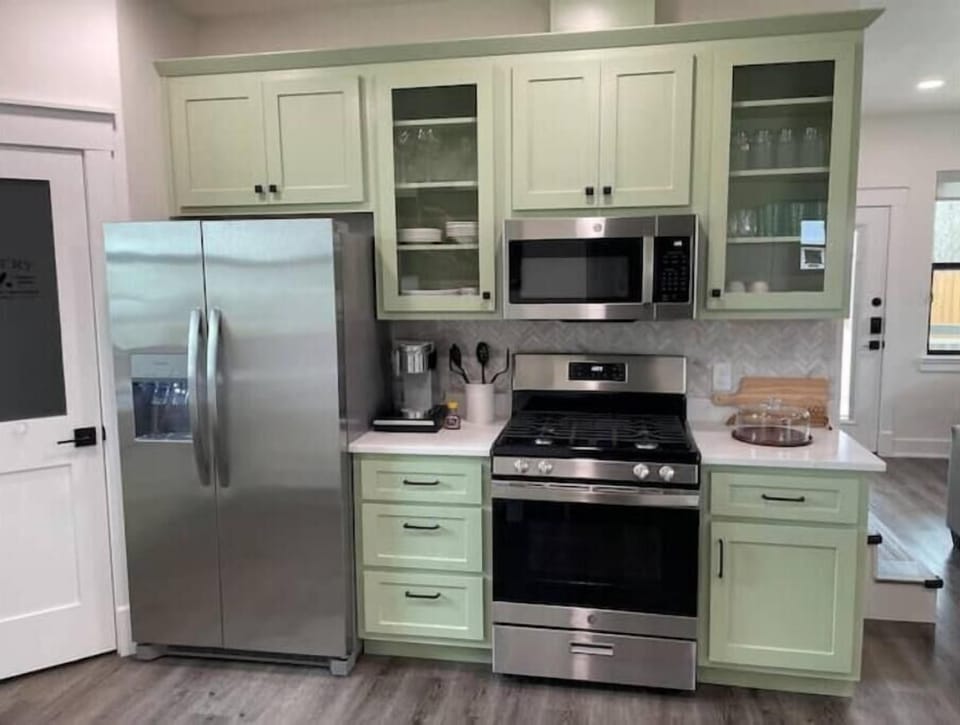 Kitchen w/ gas stove, microwave, Keurig, and refrigerator.