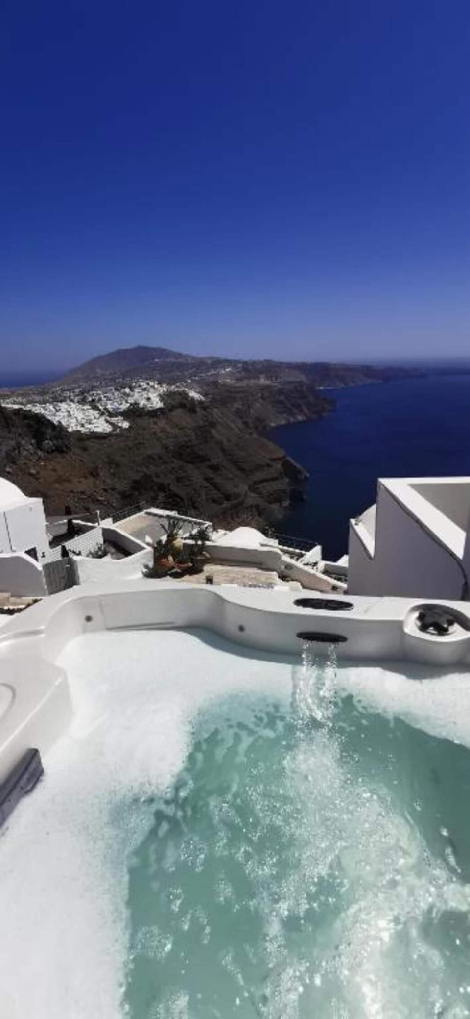 Hot tub with an amazing view to the sea and the famous volcano of Santorini