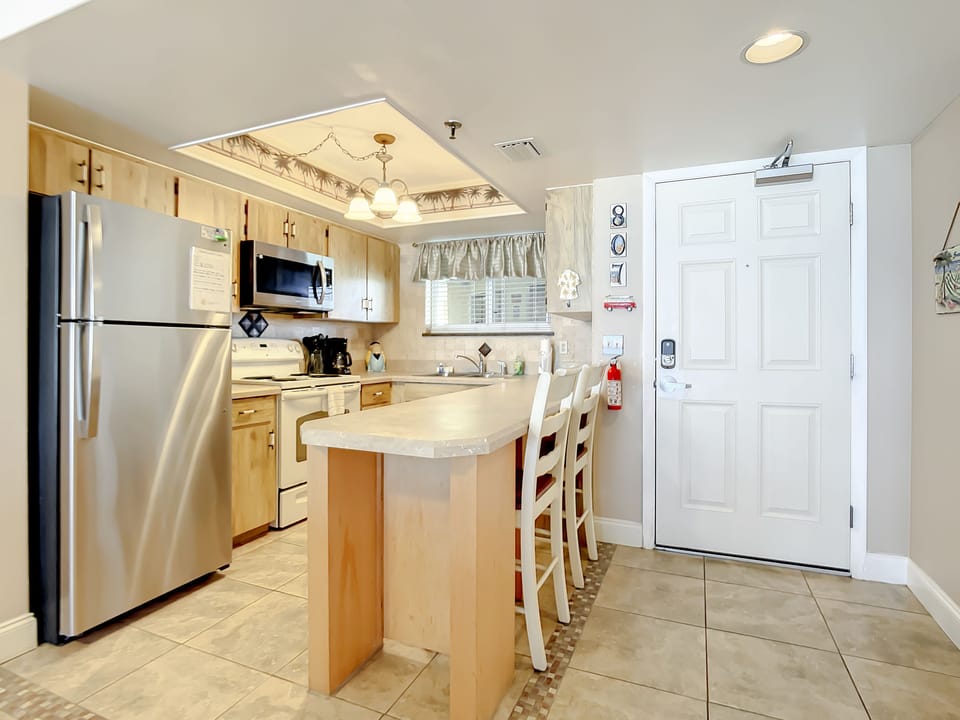 Fully equipped kitchen featuring a breakfast bar and stainless steel appliances.