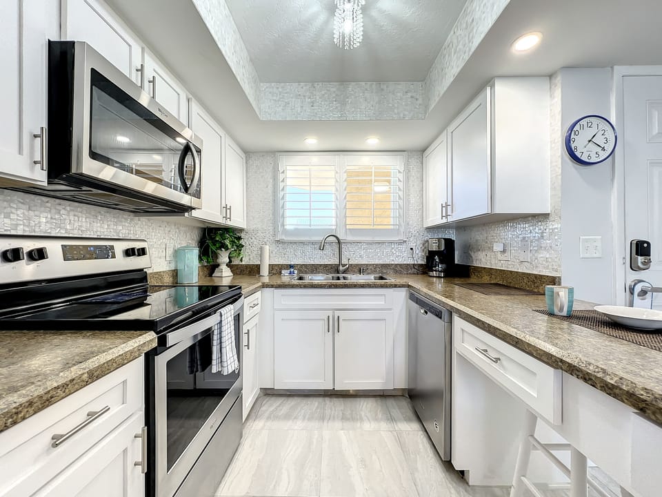 Contemporary kitchen design with stainless steel appliances, plenty of cabinets, and a sleek backsplash.