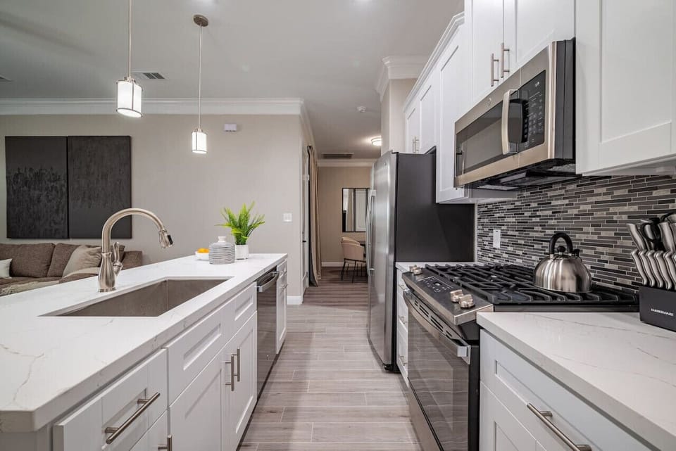Enjoy top quality stainless steel appliances, cooking utensils and pots, large deep sink, & 2 under cabinet trash cans.