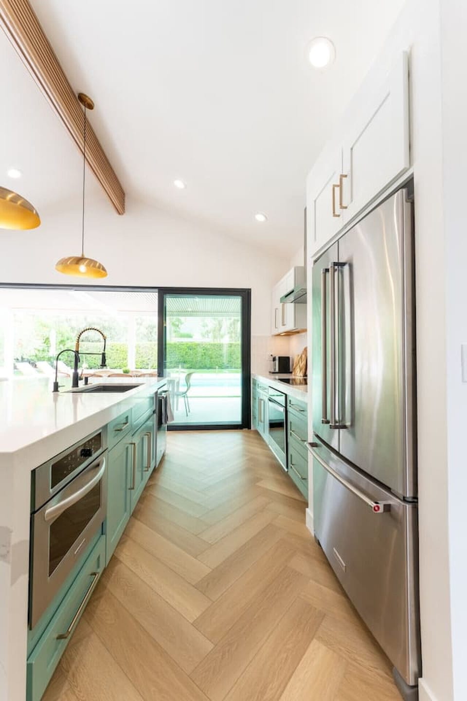 Bright kitchen w/ sleek counters, modern appliances & views out to the pool.
