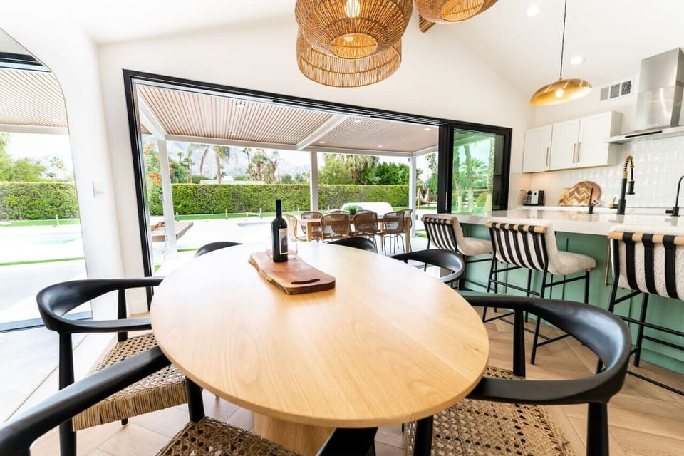 Indoor-outdoor dining setup w/ a round table, bar seating & easy access to the patio.