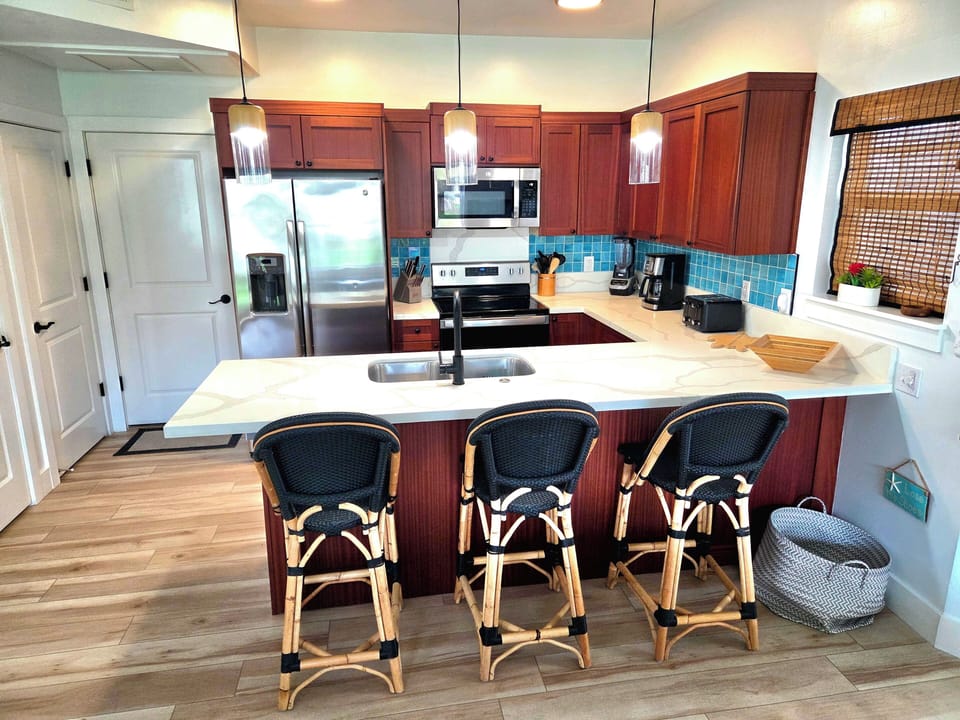 Full Kitchen, Fully Stocked, White Quartz Countertops, Aqua Backsplash Tile.