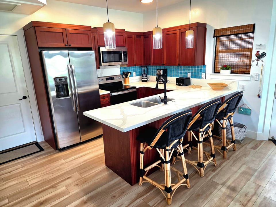 Full Kitchen, Fully Stocked, White Quartz Countertops, Aqua Backsplash Tile.