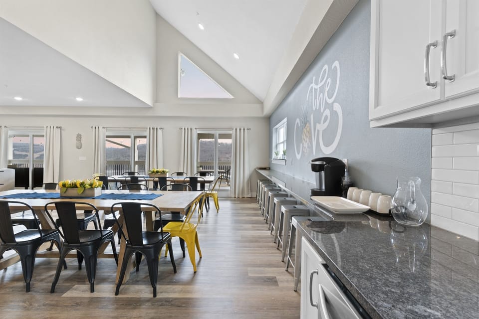 Open, airy kitchen with shades of silver, A magnificent, spacious kitchen and dining area. Chef’s kitchen is complete with a KitchenAid mixer, coffee makers, tea maker, crock pot and griddle. Sliding glass doors from the Great Room open onto the back deck.