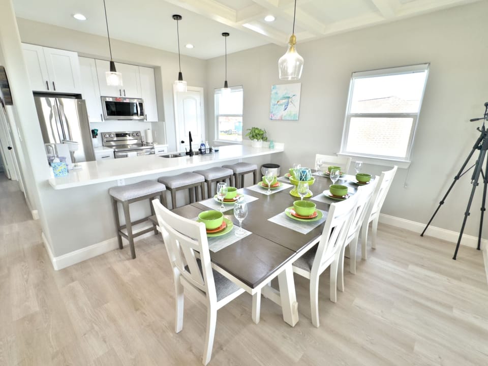 Well-lit dining area with table for 8 plus 4 at the kitchen island