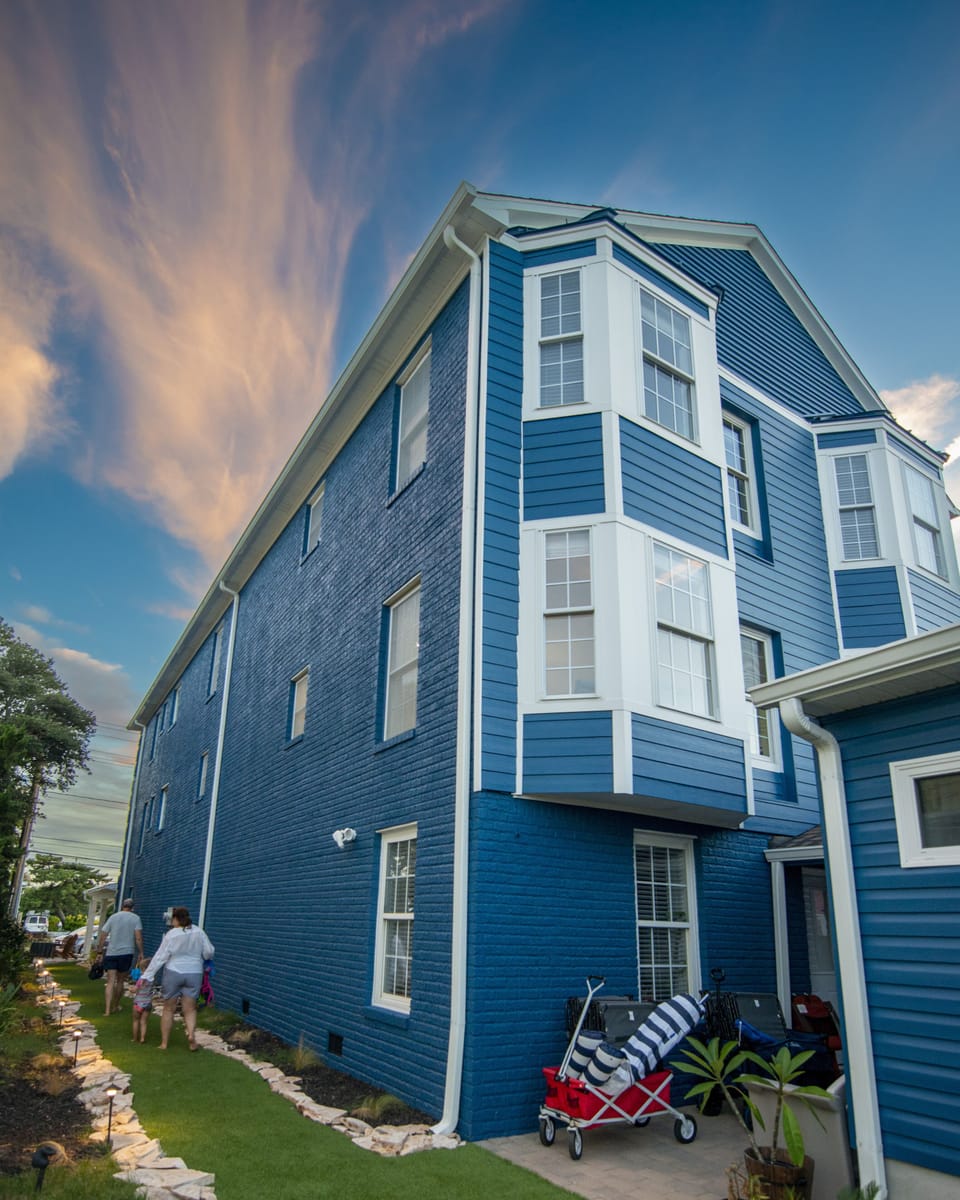 Big Blue Getaway side exterior with beach path and some beach gear.