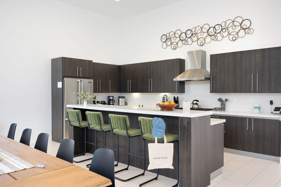 Fully-equipped kitchen with modern appliances and barstool seating at the counter.