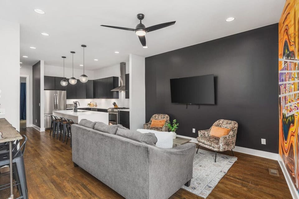 Comfortable living room with a Smart TV, ceiling fan, and plenty of seating for a game or movie night at home.