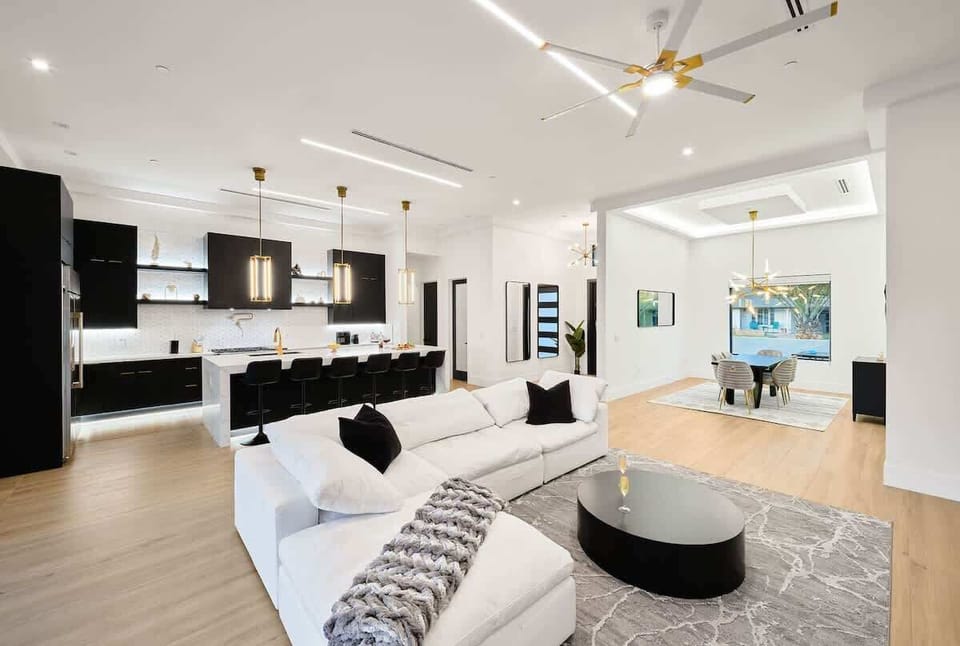 Grand designer furnished open-concept living space featuring an electric fireplace, and a Smart TV for entertainment overlooking the fully equipped kitchen.