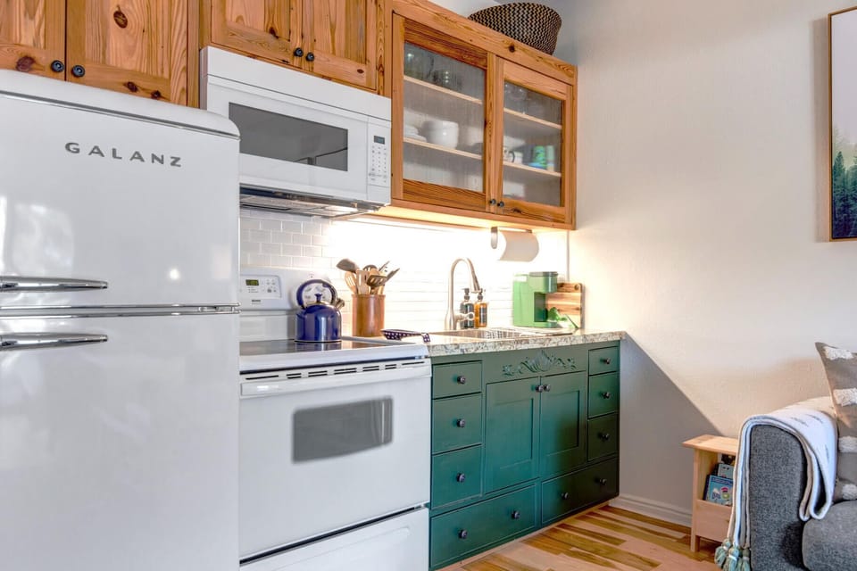 Cozy space with electric range, wood cabinets, and modern appliances.