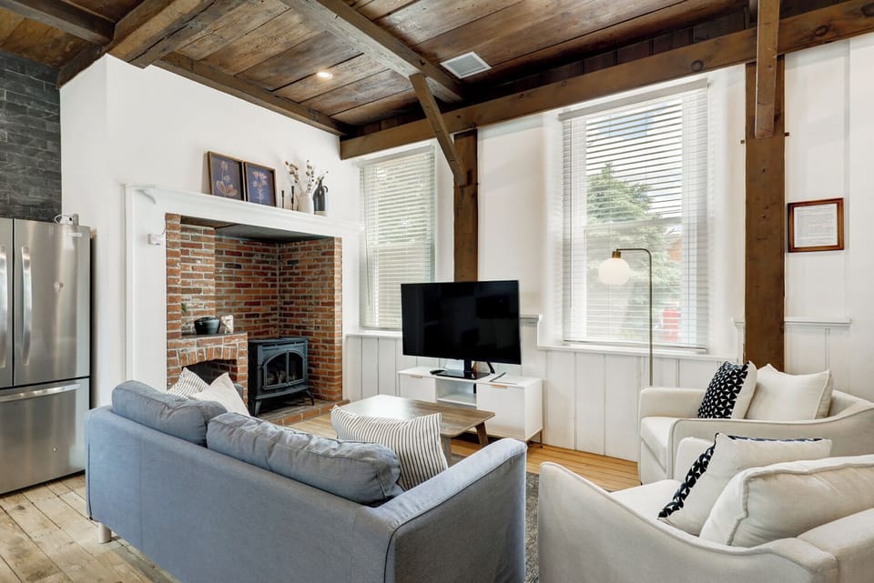 Living area and inglenook fireplace with propane fueled cast iron stove 