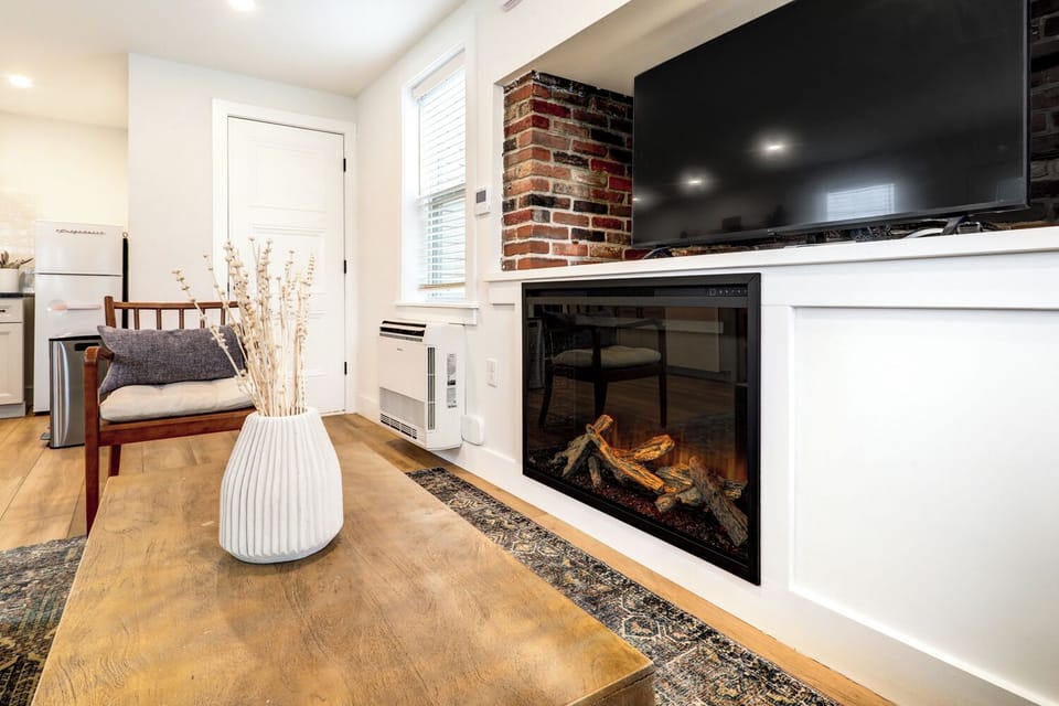 Living room area with cozy electric fireplace, bathroom is on the first floor. 