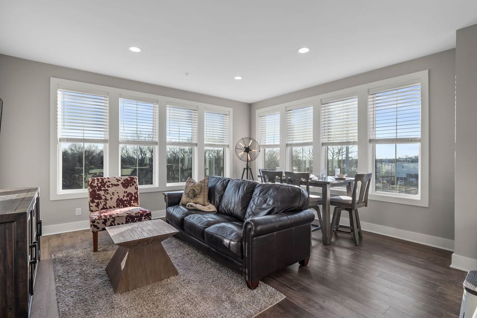 Bright open floor living space featuring a smart flat-screen TV, designer furnishings, and dining room table.