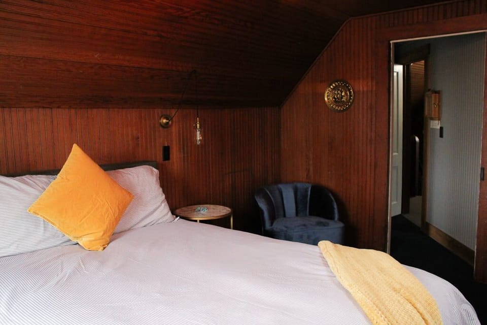 Relax with a book beside the bed in a cozy chair.
