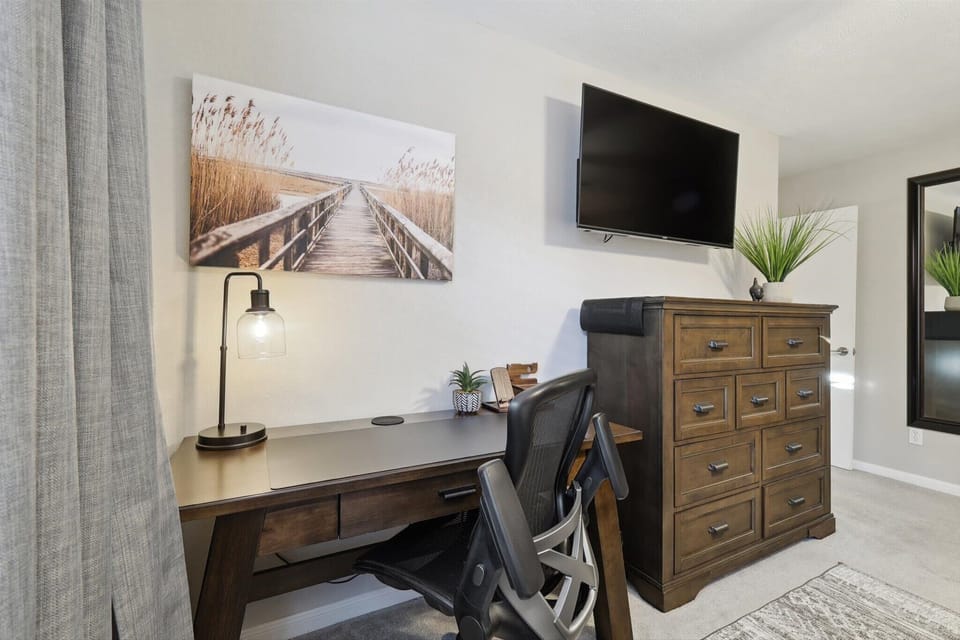Looking for a quiet space to catch up on work or studies? This bedroom features a dedicated workstation with a stylish desk, ergonomic chair, and desk lamp.