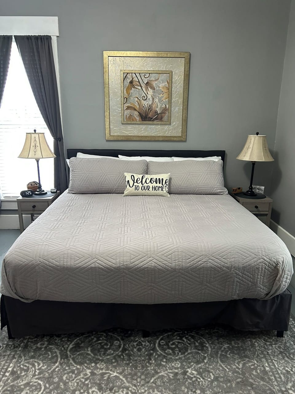 King size bed in large bedroom with custom made blinds and a ROKU TV.  