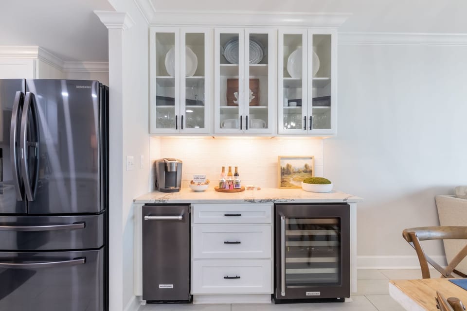 Enjoy preparing drinks and snacks at the stylish wet bar area, featuring an ice maker, wine cooler, and Keurig coffee station
