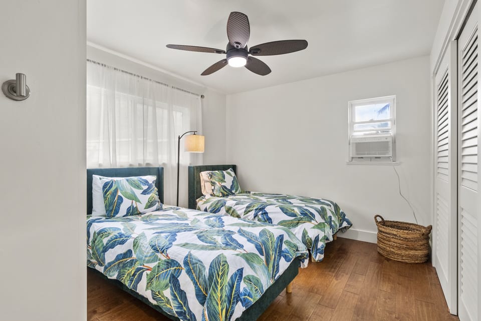 Bright twin bedroom with tropical decor and a relaxing atmosphere.