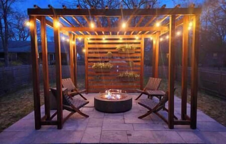 Private fenced yard with lighted pergola and fire table
