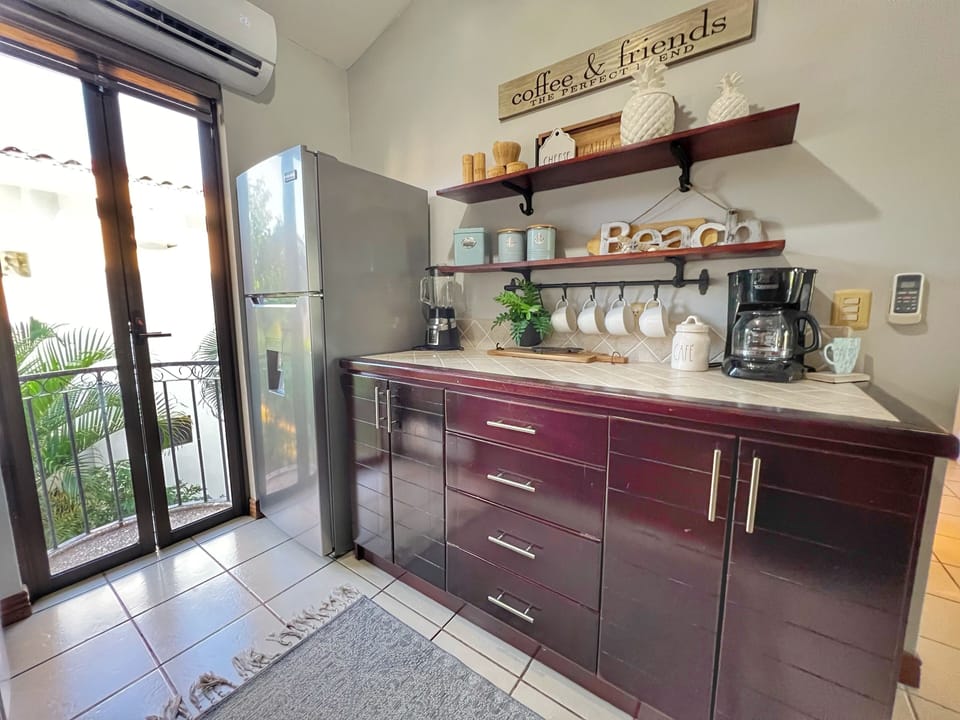 The kitchen features a full-sized refrigerator, coffee bar, small appliances and all dishware.  