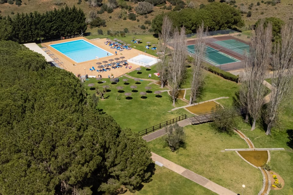 View of the pool area, tennis courts and gardens 
