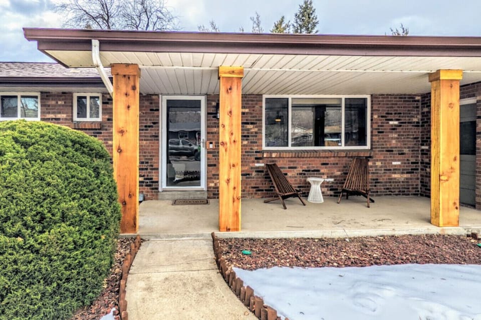 The front yard is a picturesque snowy haven, with frost-kissed trees and a soft blanket of snow covering the ground.