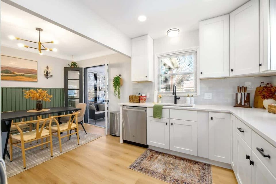 Sleek kitchen w/ long counters, bar seating & open flow into dining space