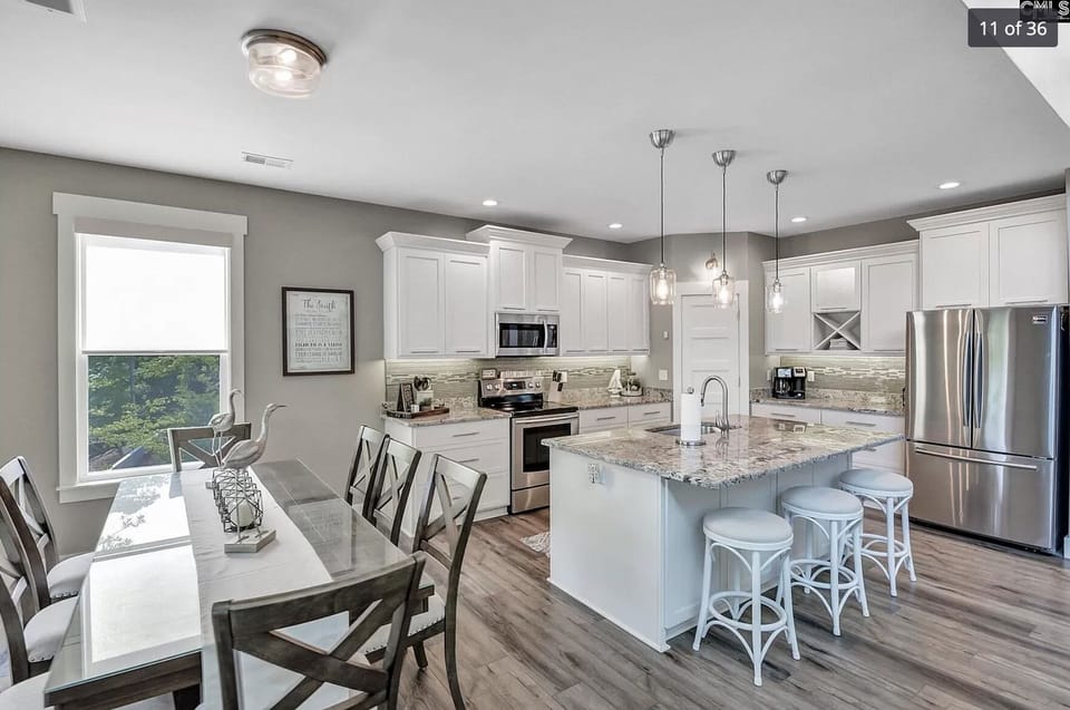 Upstairs kitchen with seating at the island and large dining table.  