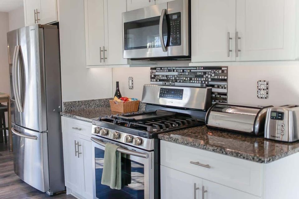 Kitchen with microwave, stove, oven, toaster, storage, and refrigerator. 