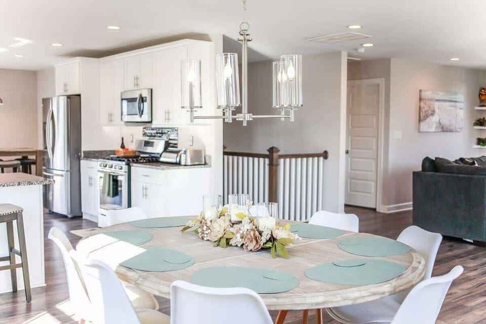 Kitchen in the background, dining room table, and living room couch. 
