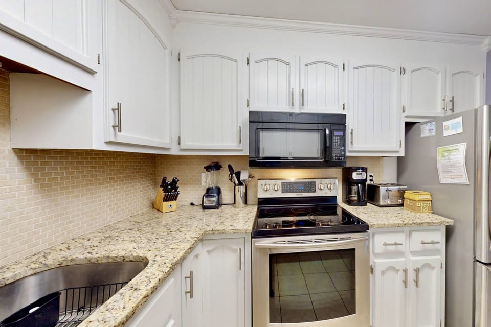 Kitchen features stainless steel appliances, new countertops and backsplash