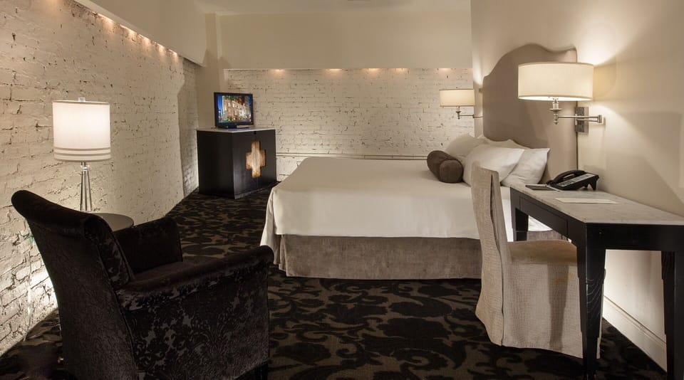 Unwind in a cozy, brick-accented room with plush bedding.