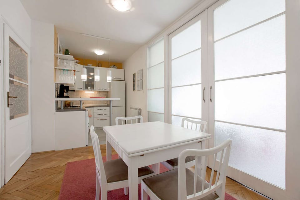 Dining area and the kitchen separated form the living room by the big glass doors.