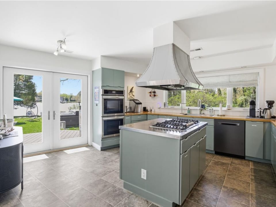 Your gourmet kitchen features a spacious island, professional-grade appliances, and French doors opening to your private outdoor dining area.