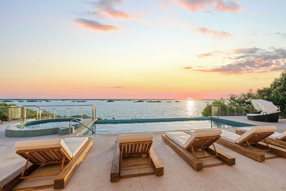 Outdoor Oasis: Relax by the pool with breathtaking sunset views over turquoise waters!