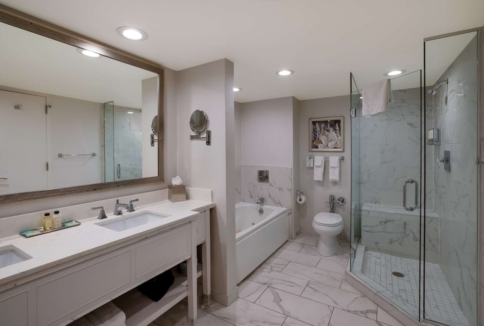Refresh in a bright marble bath with tub and shower.