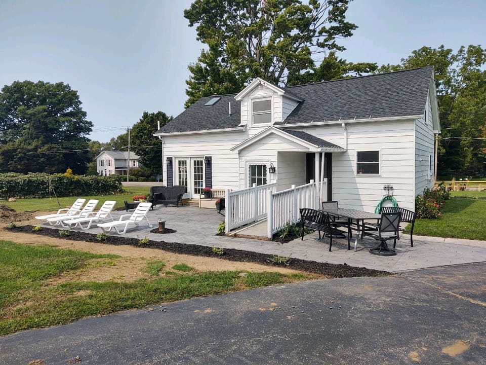 Rear patio with outside sunbathing, dining table and hot tub