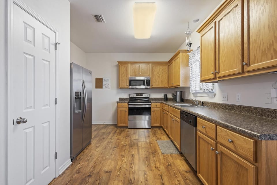 Kitchen - The spacious kitchen features stainless appliances which include a dishwasher, microwave, electric range, and refrigerator with ice maker.