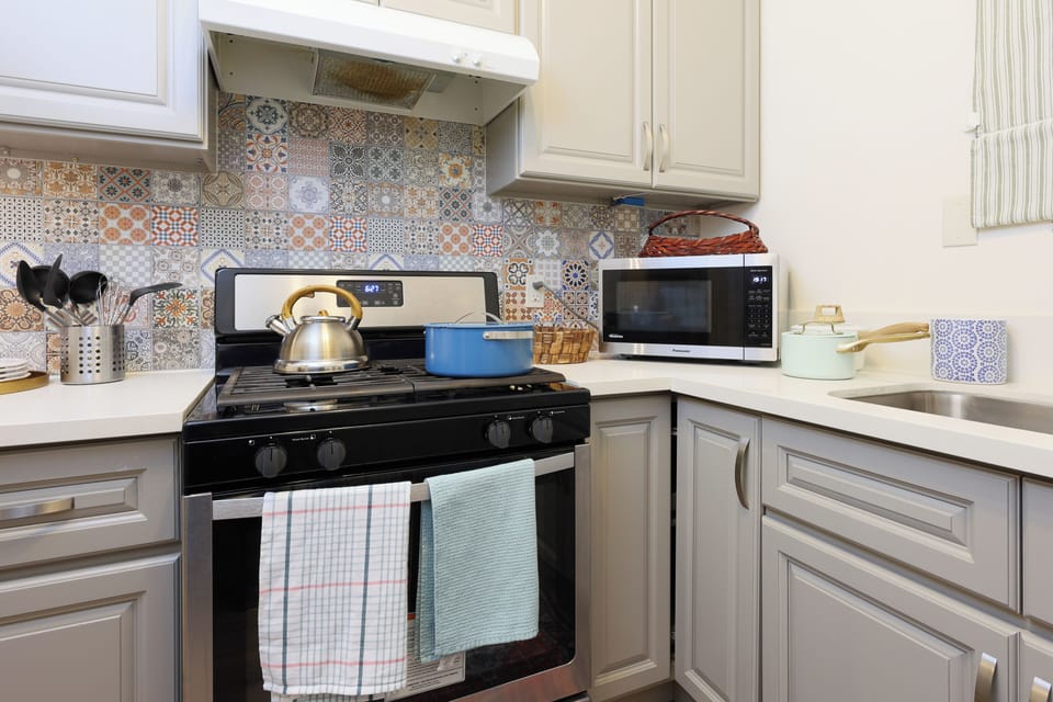 This kitchen features a stylish backsplash, modern appliances.