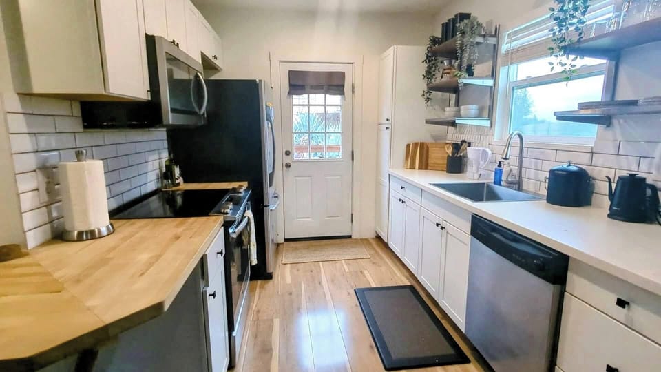 Fully stocked kitchen with dishwasher, stove, oven, coffeemaker, microwave