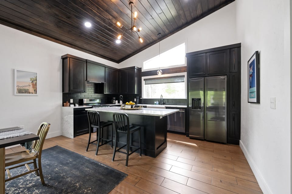 Continuing around the corner you'll see the spacious kitchen equipped with all modern major appliances and a large island for prep and additional dining space.