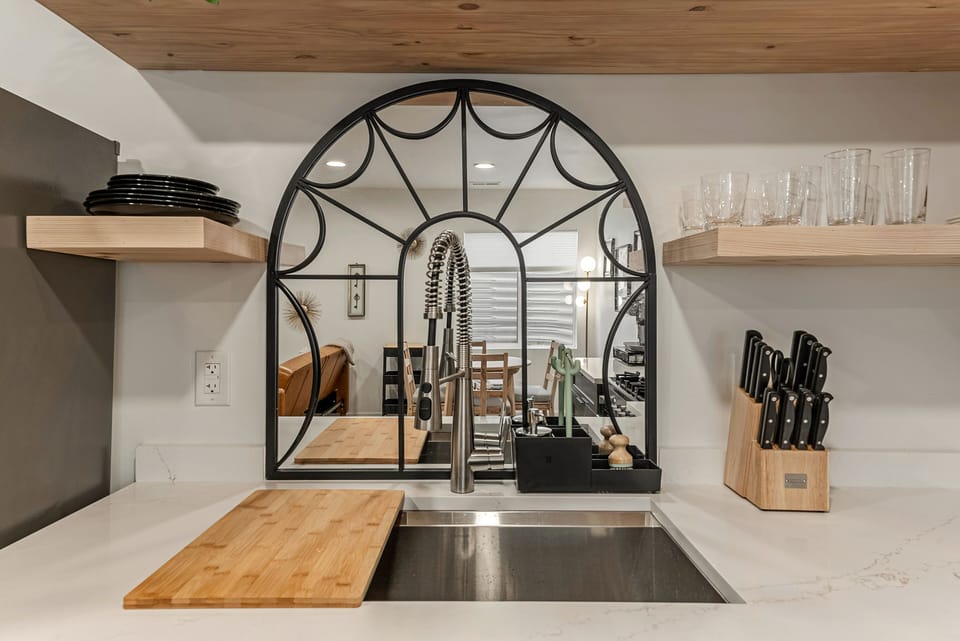 Kitchen - Large stainless steel sink and open shelving storage. 