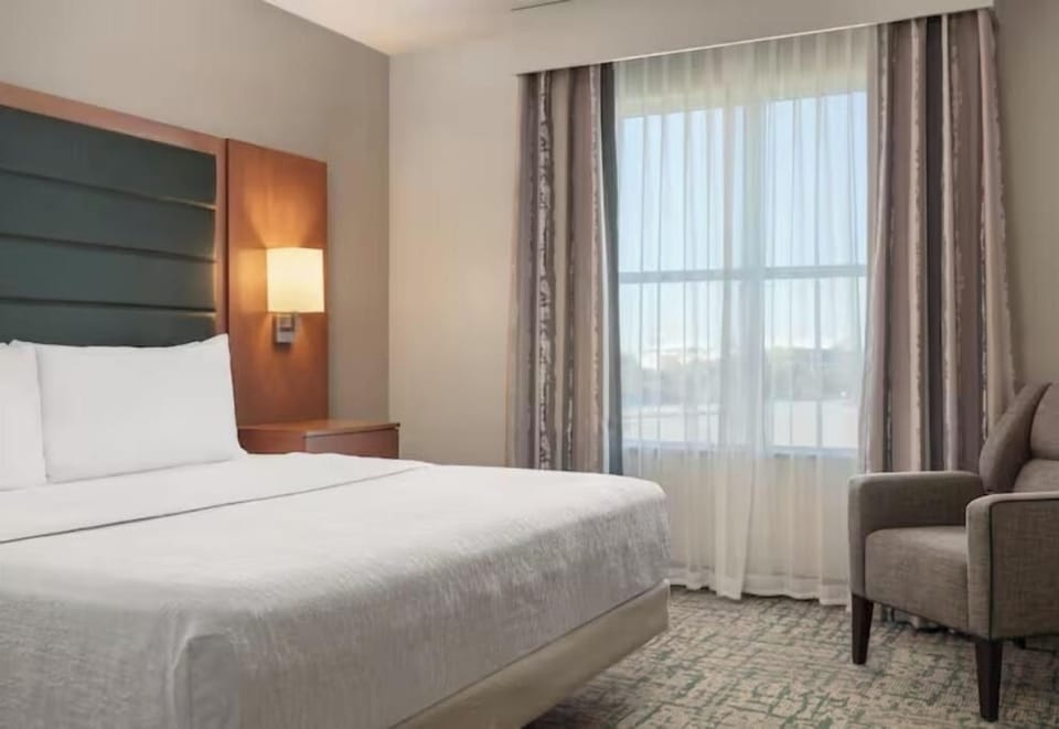 Unwind on crisp linens beside a sunlit window view.