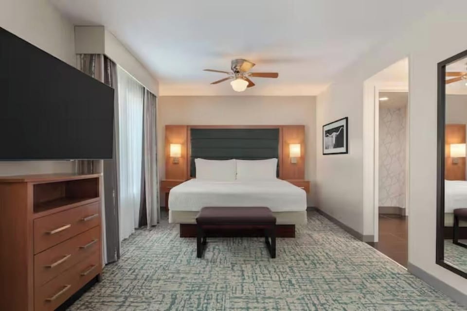 Unwind in a crisp king bed with warm, calming light.